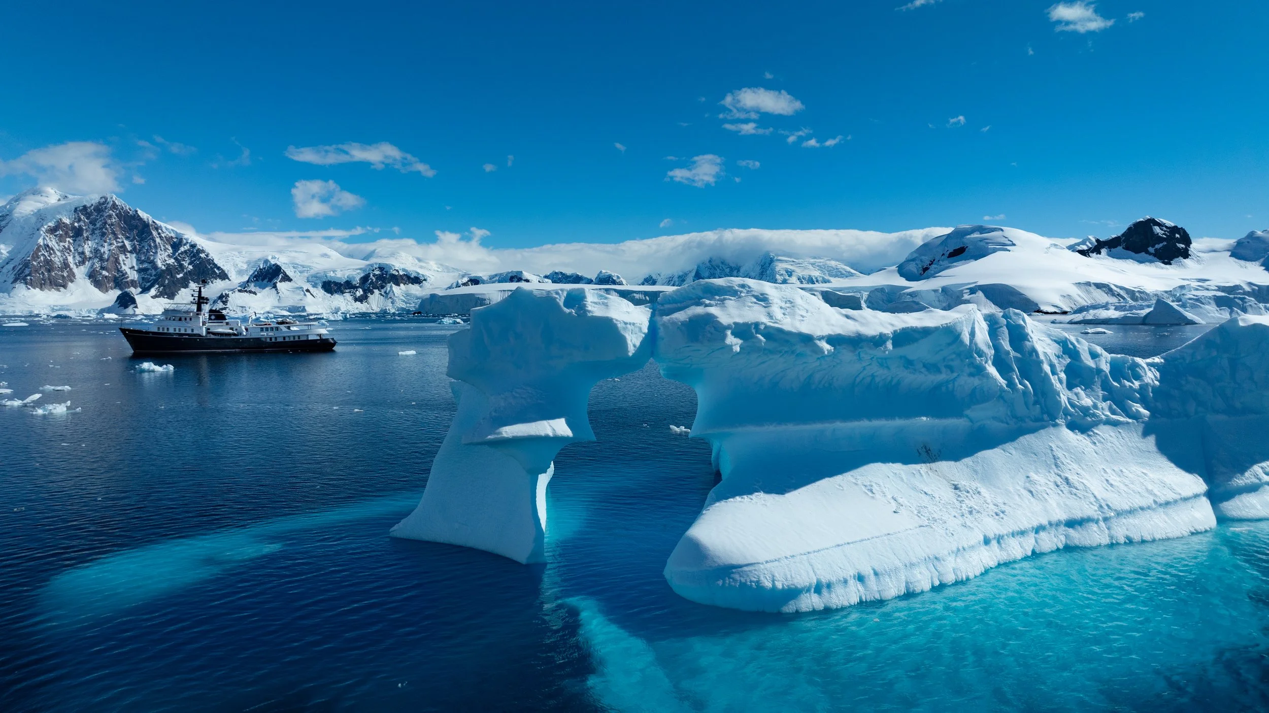 Explorer yacht at anchor among icebergs and glaciers in Antarctica