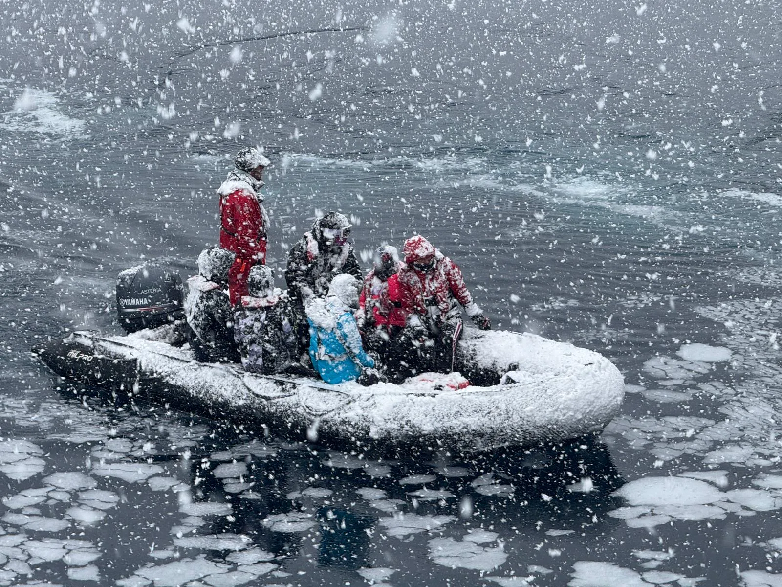 Guests aboard a zodiac tender in heavy snowfall off Neko Harbour, Antarctica